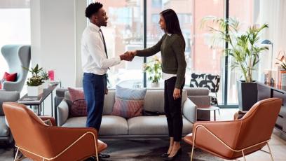 A man and a woman shaking hands after an interview. 