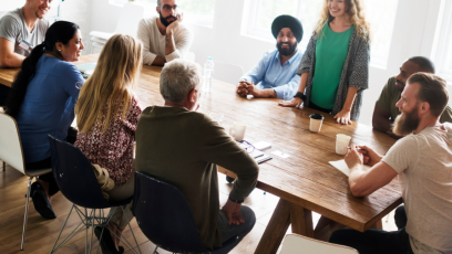 Group of people sitting around a table discussing business as part of a networking group. 