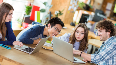 A group of people working together while on their laptops