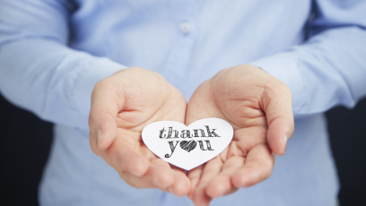 A person holding a thank you note