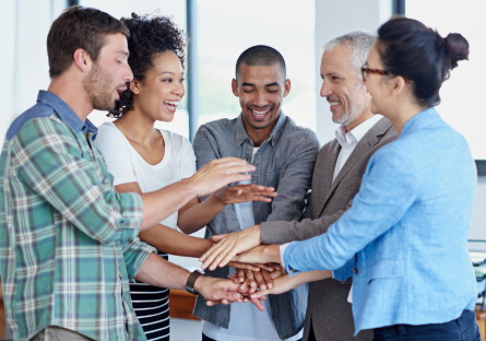 Work team in a circle using their hands to build a tower