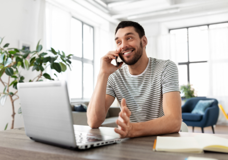 Man on phone call while working on laptop