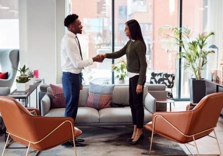 A man and a woman shaking hands after an interview. 