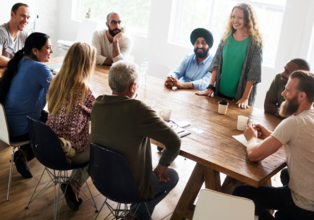 Group of people sitting around a table discussing business as part of a networking group. 