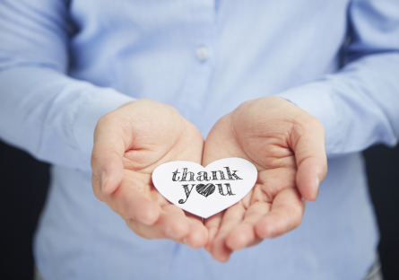 A person holding a thank you note