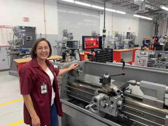 Photo of Route to Relief program graduate, Tami Smith, working as a machinist 