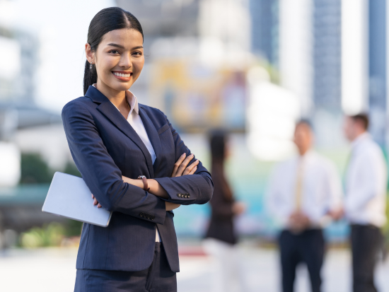 Smiling business woman standing outside of office building