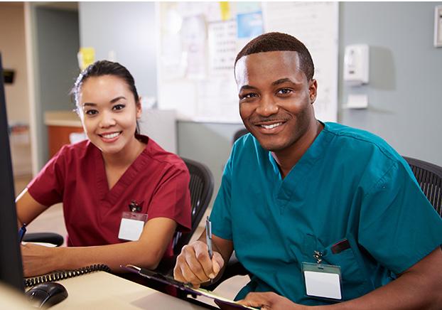 Two healthcare professionals smiling at camera