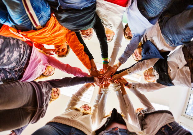 Children all putting hands together in a circle