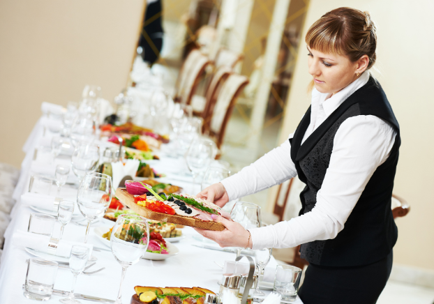 Caterer setting up food at a table