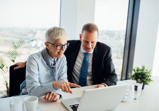 Two professionals reviewing work on a laptop