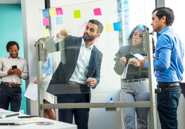 Group of employees working with post-it notes on wall