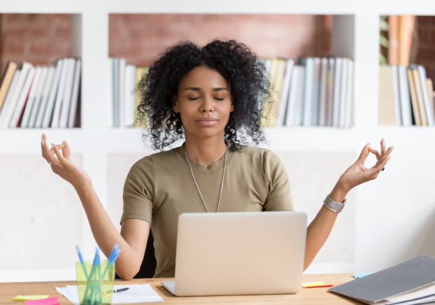 Woman practicing mindfulness in front of laptop