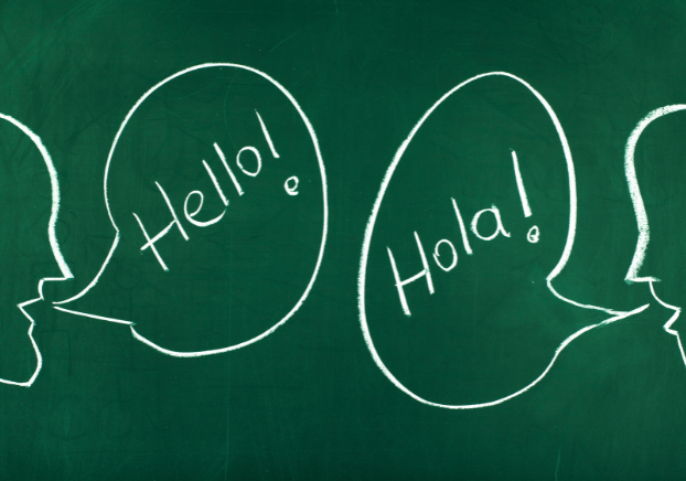 Chalkboard with talk bubbles showing English and Spanish greetings